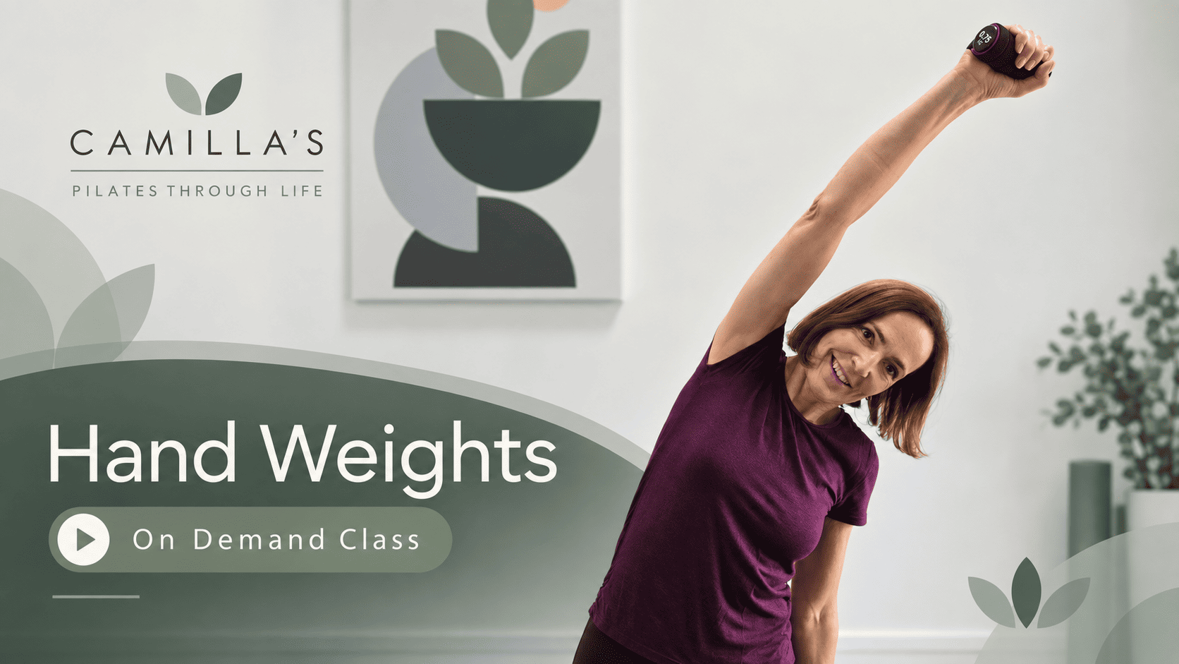 Camilla smiling while holding a hand weight overhead in an on-demand Pilates class